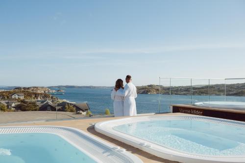 a bride and groom standing next to a swimming pool at Panorama Hotell & Resort in Steinsland
