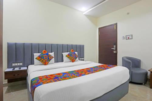 a bedroom with a large bed with colorful sheets at FabHotel RR Residency I - Nr Khammam Bus Stand in Khammam