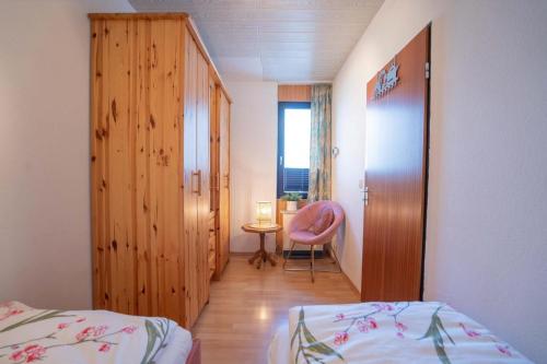 a bedroom with a bed and a chair and a table at Inselblume 11 - Ferienunterkunft am Yachthafen auf Fehmarn in Burgtiefe auf Fehmarn 