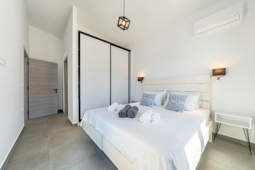 a bedroom with a white bed with towels on it at Costa Mediterranea in Gaios