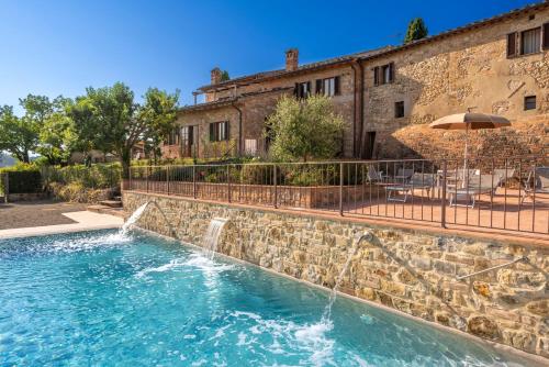 a swimming pool with a waterfall in front of a building at Tenuta Sovestro - Agriturismo e winery in San Gimignano