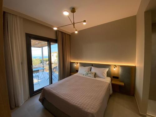 a bedroom with a bed and a large window at Spitaki Among Olives in Tsoukaladhes