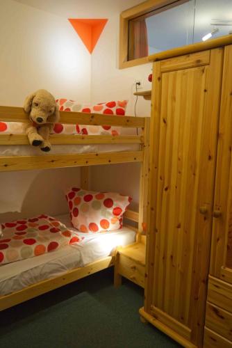 a bedroom with two bunk beds and a teddy bear at Inselblume 02 - Maritime Ferienwohnung, Blick zum Yachthafen in Burgtiefe auf Fehmarn 