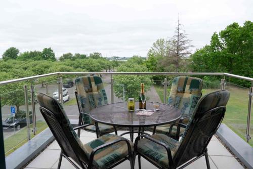 a table and chairs on a balcony with a view at Inselblume 02 - Maritime Ferienwohnung, Blick zum Yachthafen in Burgtiefe auf Fehmarn 