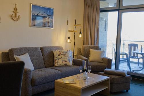 a living room with a couch and chairs and a table at Inselblume 02 - Maritime Ferienwohnung, Blick zum Yachthafen in Burgtiefe auf Fehmarn 