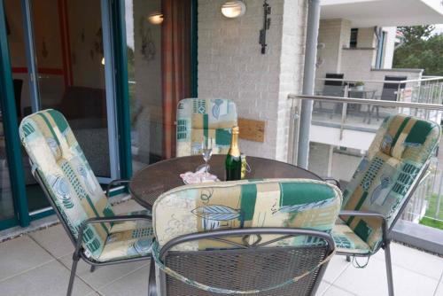 a table and chairs with a bottle of wine at Inselblume 02 - Maritime Ferienwohnung, Blick zum Yachthafen in Burgtiefe auf Fehmarn 