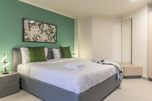 a bedroom with a large bed with green walls at CityZen - Boutique Studios in Achrafieh in Beirut