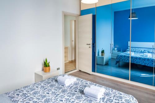 a blue bedroom with a bed and a mirror at Casa Lina - Apartment with lake view in Dagnente