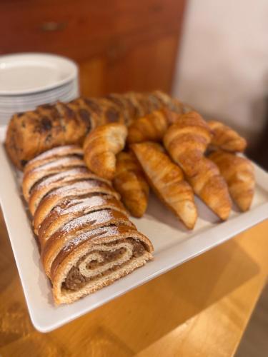 a plate of bread and croissants on a table at Wellness Penzion Zora Family in Tatranská Lomnica