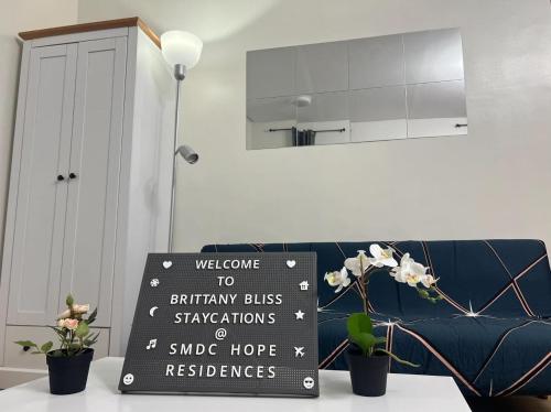 a sign sitting on a table in a living room at Brittany Bliss Staycations at SMDC HOPE RESIDENCES in Trece Martires