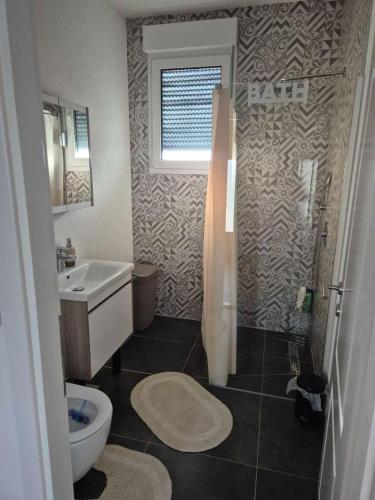 a bathroom with a toilet and a sink and a shower at Kuca za odmor B in Kosor