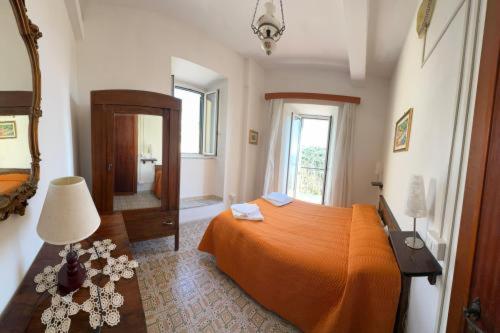 a bedroom with an orange bed and a mirror at Alloggio turistico - Sole dall'alba al tramonto in Sezze