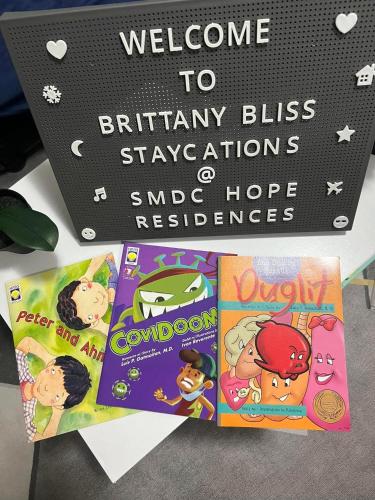 a bunch of childrens books sitting on a table at Brittany Bliss Staycations at SMDC HOPE RESIDENCES in Trece Martires