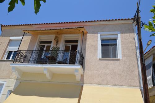 a building with a balcony and a window at Avlonari Evias flat in the Central Square in Avlonárion