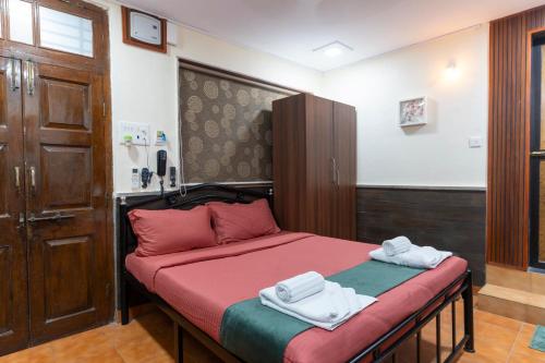 a bedroom with a bed with towels on it at Nestay in Karnāla