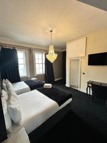 a hotel room with two beds and a chandelier at White Star Line Hotel in Liverpool