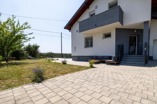 a house with a brick patio in front of it at Three-Bedroom Holiday Home Vida with Private Pool in Zagreb