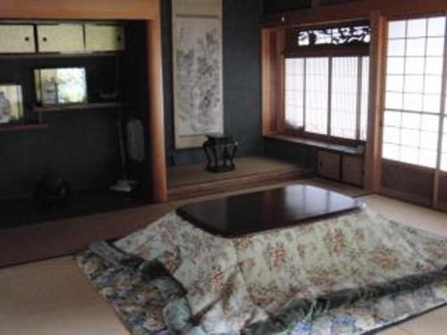 a living room with a table and two windows at B & B Nishimine in Uda