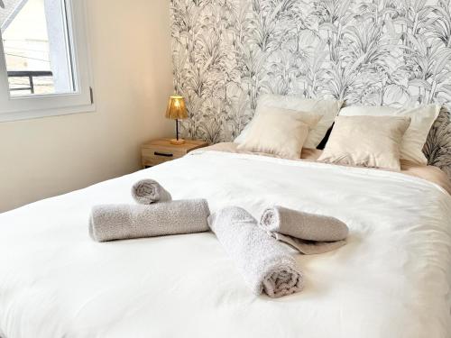 a bedroom with a white bed with towels on it at Studio clair rivage centre-ville in Lorient