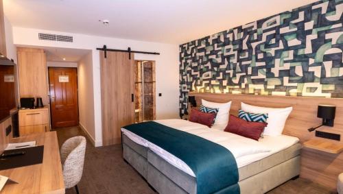 a hotel room with a large bed and a desk at Hotel Gladbeck van der Valk in Gladbeck
