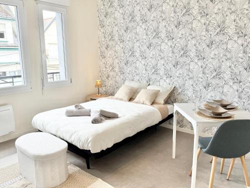 a bedroom with a bed and a table and a wall at Studio clair rivage centre-ville in Lorient