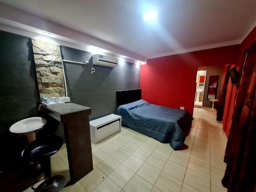 a bedroom with a bed and a red wall at Farolito de Luz Apart in Salta