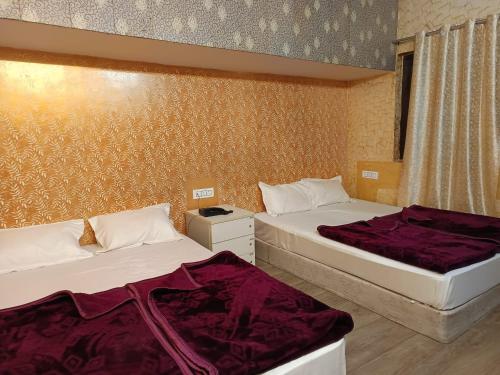 a room with two beds and a window at Family Hotel -1 Min Walk in Nizamuddin Railway Station in New Delhi
