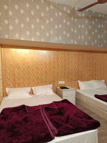 a bedroom with two beds and a wall at Family Hotel -1 Min Walk in Nizamuddin Railway Station in New Delhi