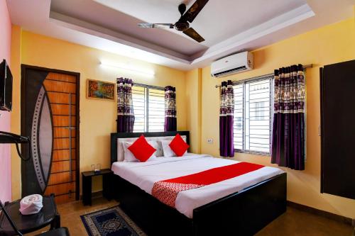 a bedroom with a large bed with red pillows at Super Hotel O Ashiyana Guest House in kolkata
