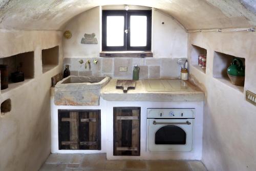 a kitchen with a sink and a stove at Casa Nachiro - 16th Century Oil Mill Historic Dimora in Nardò