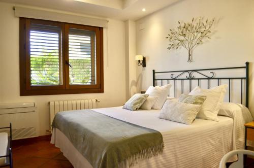 a bedroom with a bed with white sheets and a window at Hotel La Gastrocasa - Adults Only in Gandía