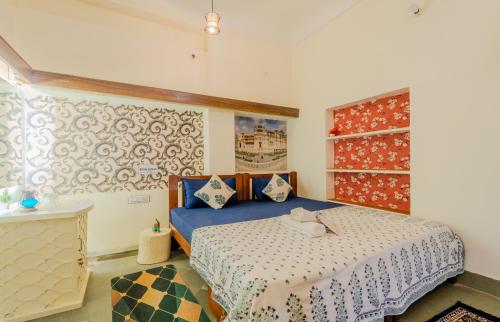a bedroom with a bed with a blue comforter at Travellers Village-City Center Hertige Home in Jaipur