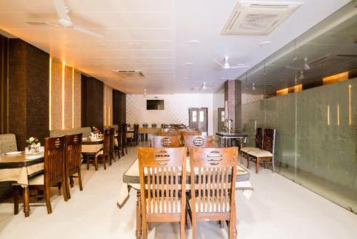a dining room with tables and chairs in a restaurant at Hotel Manas Continental Gorakhpur in Gorakhpur