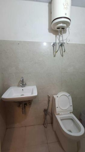 a bathroom with a sink and a toilet at Family Hotel -1 Min Walk in Nizamuddin Railway Station in New Delhi