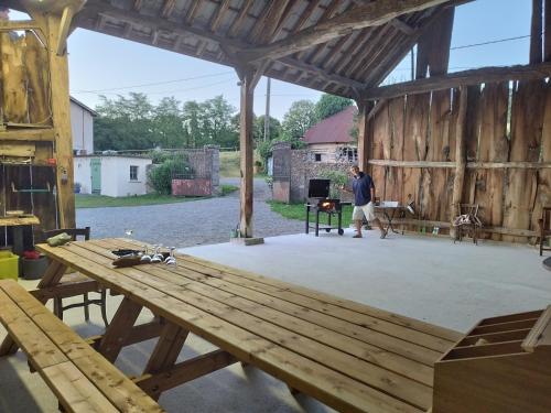 a man standing inside of a barn with a picnic table at La grange ô merles in Arrien