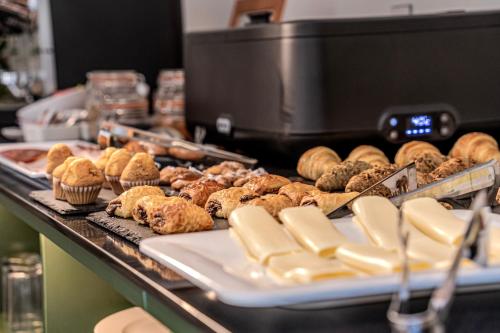 a bunch of pastries and muffins on a counter at ITC Madrid by Soho Boutique in Madrid