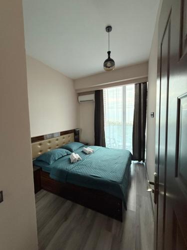バトゥミにあるMetrocity apartments with Seaviewのベッドルーム(緑のベッド1台、窓付)