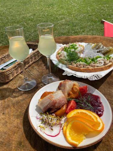 a table with a plate of food and two glasses of wine at Olza Karczma i pokoje in Istebna