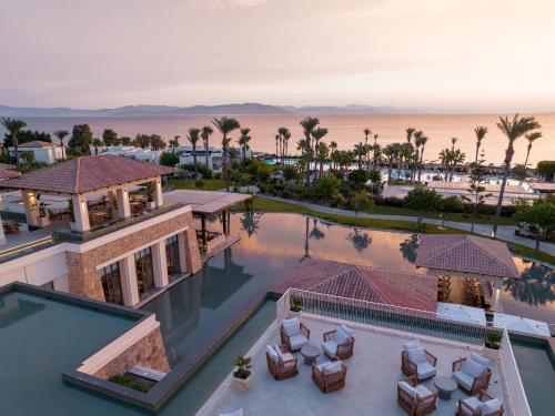 an aerial view of a resort with a pool and palm trees at Grecotel LUXME Kos in Kos Town