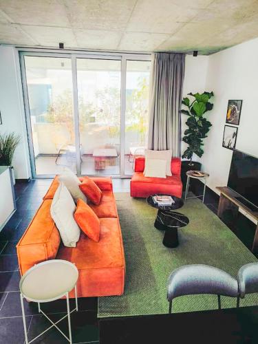 a living room with a orange couch and chairs at Bridge House 301-3BR Penthouse in Limassol