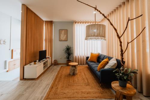 a living room with a blue couch and a tv at Maresia - Esmoriz Beach in Esmoriz