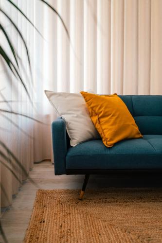 a blue couch with two pillows on it in a room at Maresia - Esmoriz Beach in Esmoriz