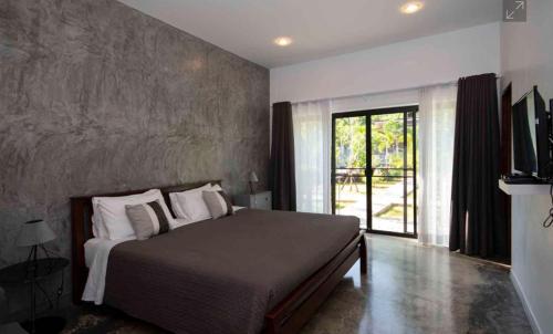a bedroom with a large bed and a large window at Krabi Home and Beyond-Ao Nang in Ao Nang Beach