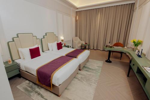 a hotel room with a large bed and a desk at The Tivoli New Delhi in New Delhi