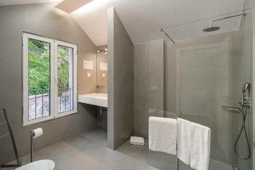 a bathroom with a shower and a toilet and a sink at OurMadeira - Babosas Village, gardénias and greenspaces in Funchal