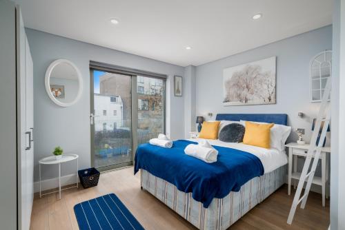a bedroom with a blue bed and a window at Ultra Luxury Riverside Condo Central London Notting Hill with LIFT & Juliet balcony in London