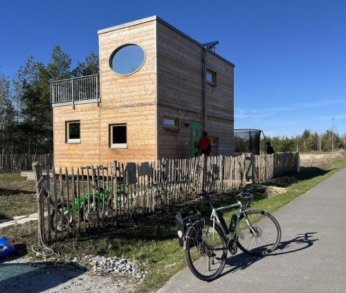 a building with a bike parked next to a fence at Holzhaus am Bergheider See in Buschmühle