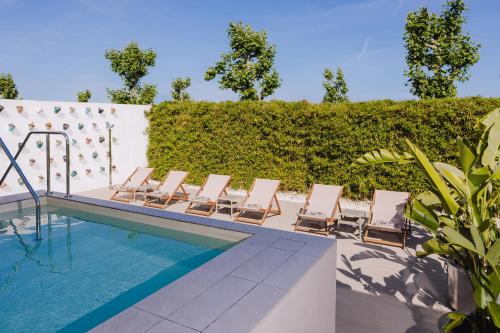 a row of lounge chairs next to a swimming pool at INNSiDE by Meliá Barcelona Aeropuerto in El Prat de Llobregat