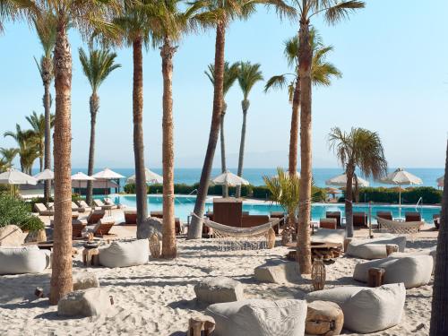 a resort with palm trees and a swimming pool at Grecotel LUXME Kos in Kos Town