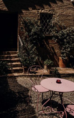 a table and chairs sitting in front of a building at Fattoria Le Pietre Vive di Montaperti in Montaperti